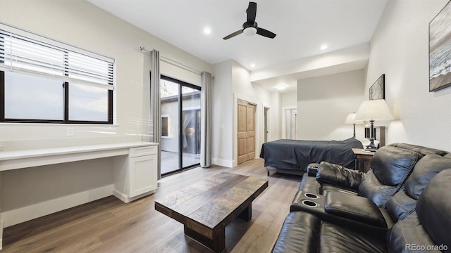 bedroom with ceiling fan, built in desk, light hardwood / wood-style floors, and access to outside