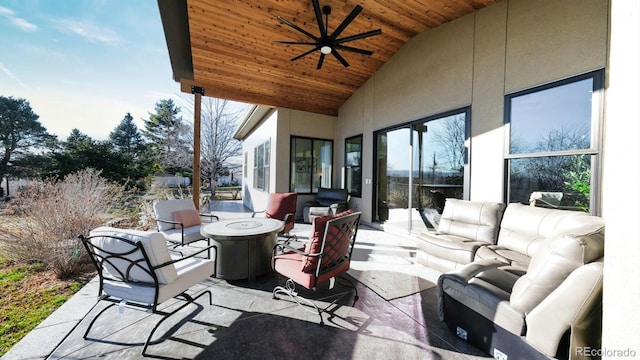 view of patio with ceiling fan and an outdoor living space with a fire pit