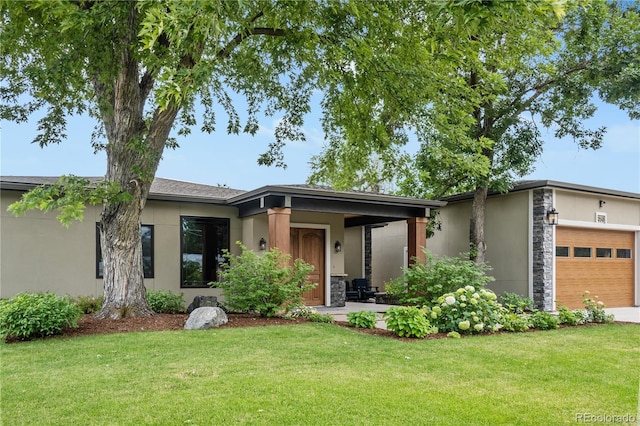 view of front of home featuring an attached garage, stone siding, a front lawn, and stucco siding