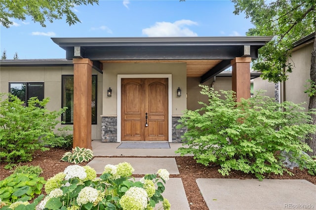 property entrance featuring stone siding and stucco siding