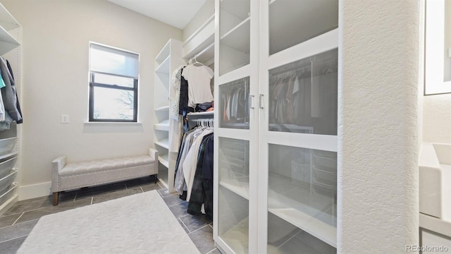 spacious closet featuring dark tile patterned floors