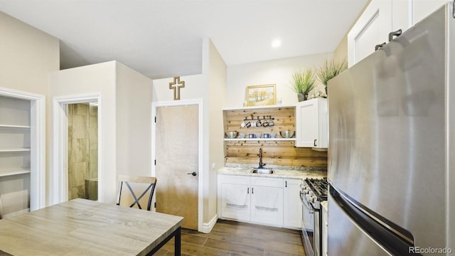 kitchen featuring open shelves, appliances with stainless steel finishes, dark wood-type flooring, white cabinetry, and a sink