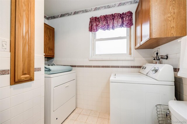 359 S 25th Ave, Brighton, CO 80601 - laundry room with tile walls, washing machine and dryer, a wainscoted wall, cabinet space, and light tile patterned floors