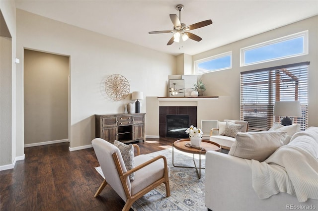 living area featuring a tile fireplace, wood finished floors, a ceiling fan, and baseboards