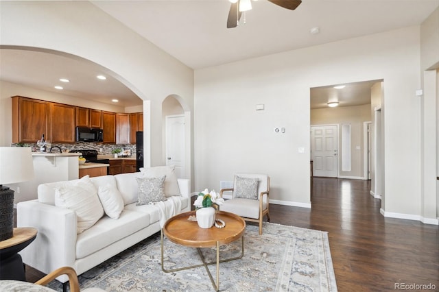 living area with baseboards, arched walkways, dark wood finished floors, ceiling fan, and recessed lighting