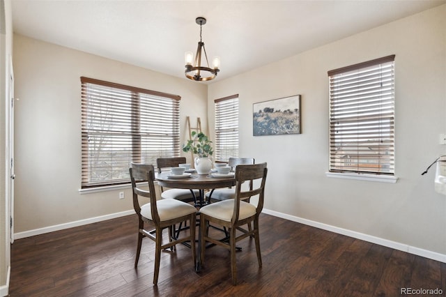 dining area with a chandelier, dark wood-type flooring, and baseboards