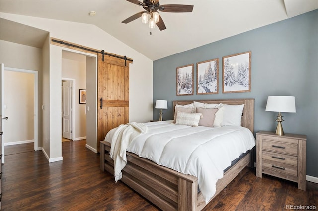 bedroom with dark wood-type flooring, vaulted ceiling, baseboards, and a barn door