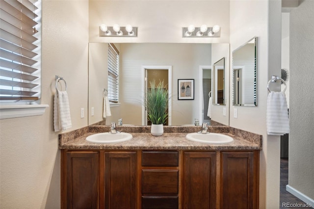 full bathroom with double vanity and a sink