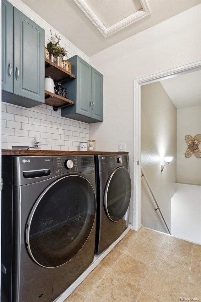 laundry room with cabinet space, washing machine and dryer, and light tile patterned floors