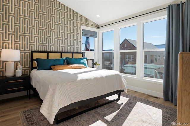 bedroom with vaulted ceiling and hardwood / wood-style flooring