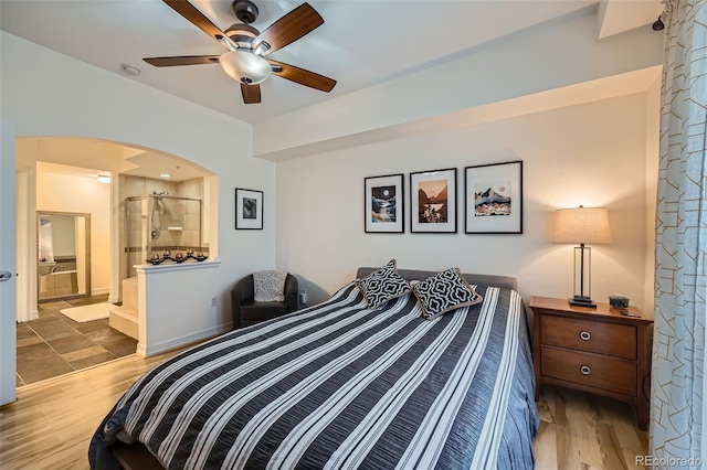 bedroom featuring hardwood / wood-style floors, ensuite bathroom, and ceiling fan