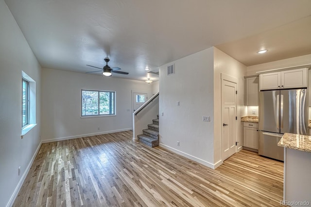 unfurnished living room featuring ceiling fan and light hardwood / wood-style flooring