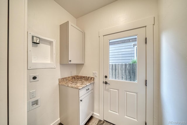 interior space featuring cabinets, hookup for a washing machine, hardwood / wood-style floors, and hookup for an electric dryer