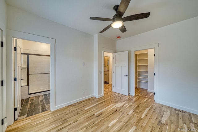 unfurnished bedroom with ceiling fan, light hardwood / wood-style floors, a closet, and a spacious closet