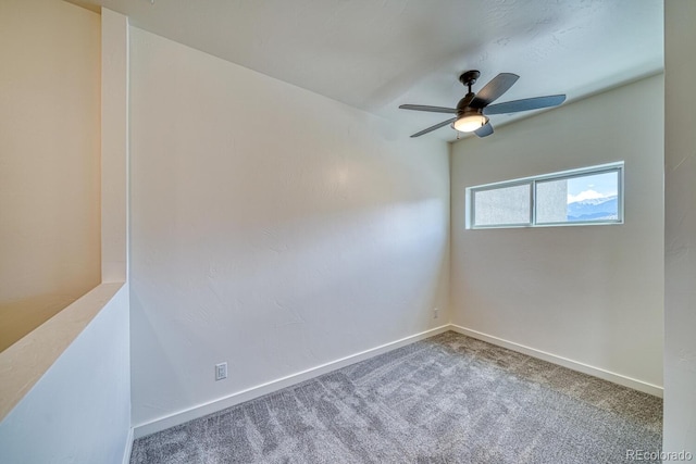 empty room featuring ceiling fan and carpet