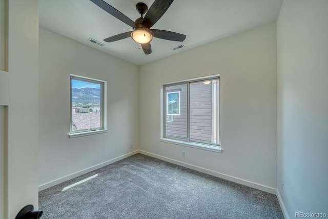 carpeted spare room featuring ceiling fan