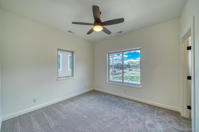 empty room with ceiling fan and light carpet