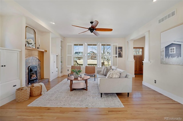 11776 Perry St, Westminster, CO 80031 - living room featuring visible vents, a ceiling fan, light wood finished floors, and decorative columns