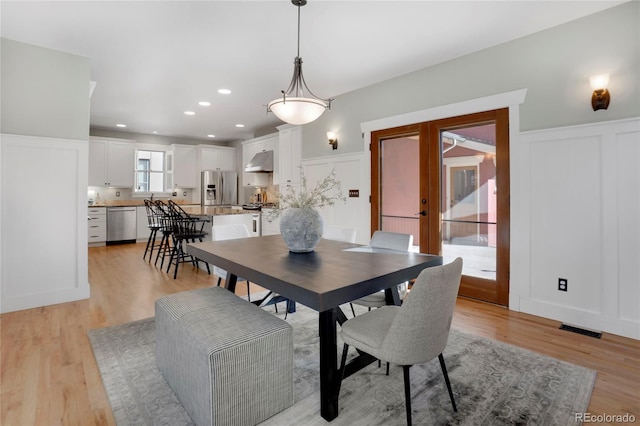 11776 Perry St, Westminster, CO 80031 - dining area featuring wainscoting, a decorative wall, light wood-type flooring, and visible vents