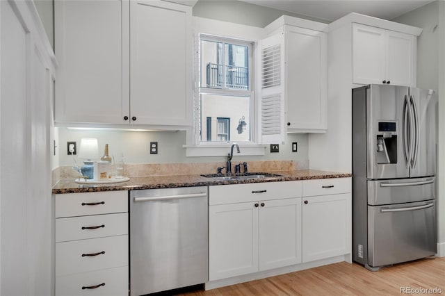 11776 Perry St, Westminster, CO 80031 - kitchen featuring a sink, dark stone counters, appliances with stainless steel finishes, and white cabinetry