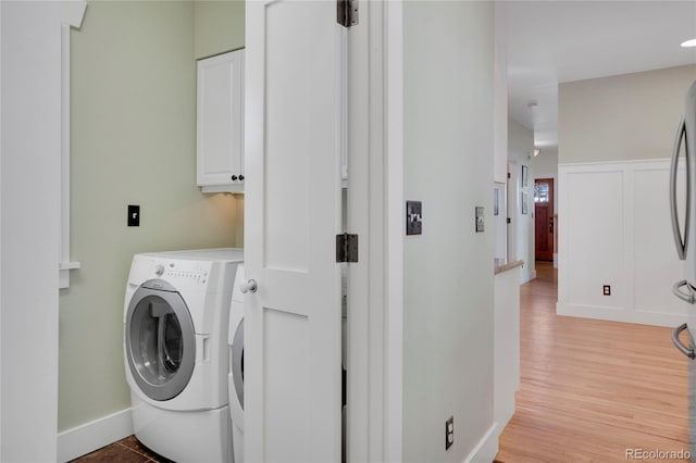 11776 Perry St, Westminster, CO 80031 - washroom with separate washer and dryer, baseboards, light wood-type flooring, and cabinet space