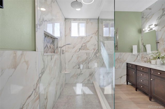 11776 Perry St, Westminster, CO 80031 - bathroom featuring a wainscoted wall, tile walls, a marble finish shower, and vanity