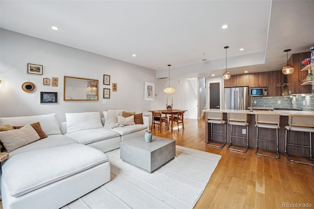 living area featuring light wood-type flooring and recessed lighting