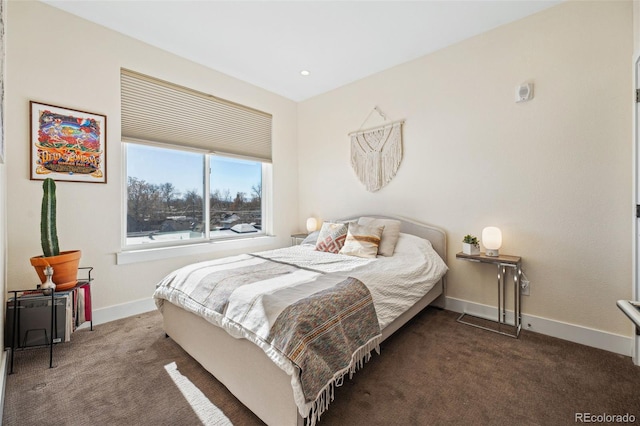 bedroom featuring dark colored carpet and baseboards