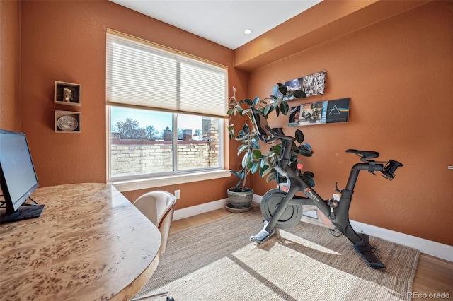 exercise area featuring baseboards and wood finished floors