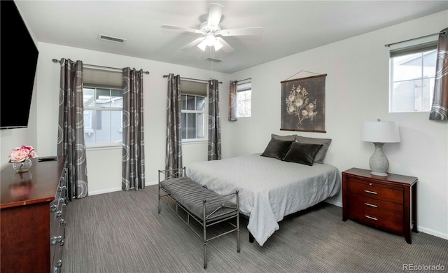 bedroom featuring multiple windows, ceiling fan, and carpet