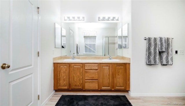 bathroom with vanity, a shower with shower door, and hardwood / wood-style floors