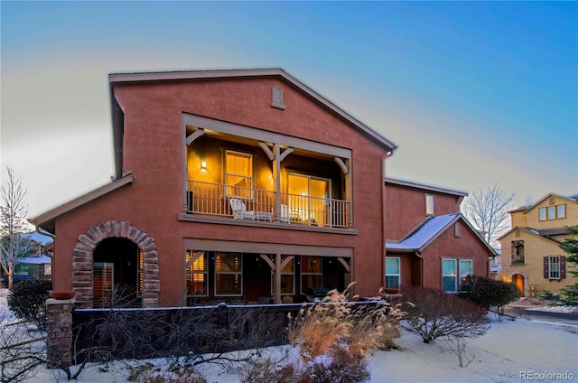 snow covered property with a balcony