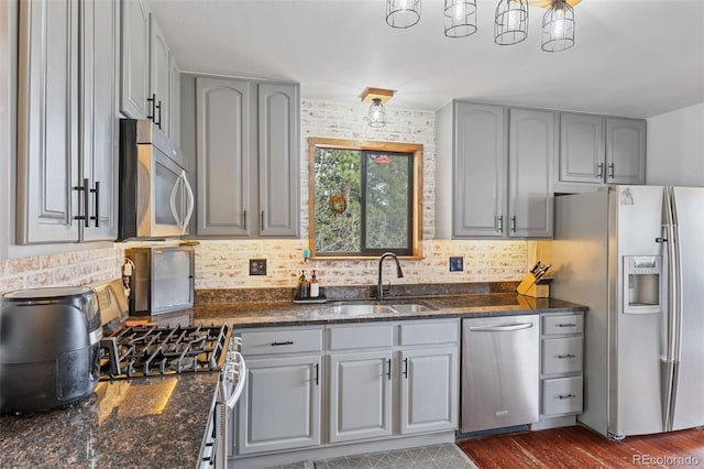 518 Pine Dr, Bailey, CO 80421 - kitchen with appliances with stainless steel finishes, gray cabinetry, backsplash, and dark stone counters