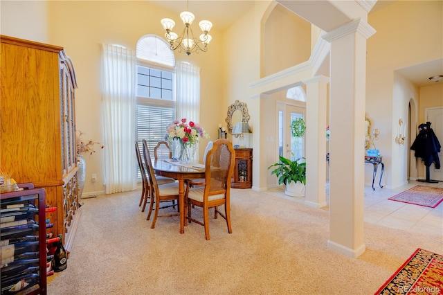 dining area with ornate columns, a towering ceiling, light carpet, and a notable chandelier