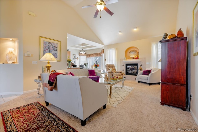 carpeted living room featuring ceiling fan with notable chandelier and high vaulted ceiling