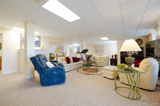 living room with a drop ceiling and carpet flooring