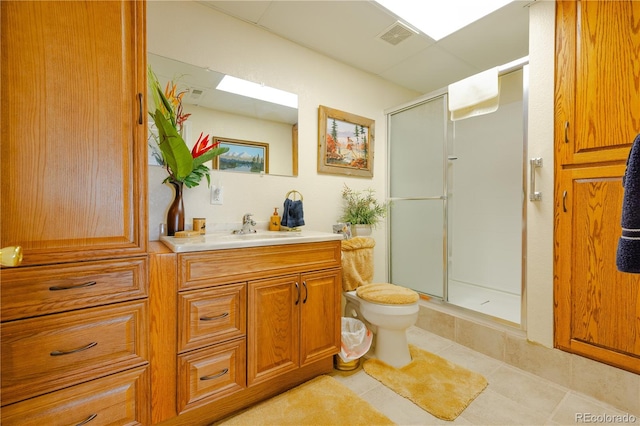 bathroom with vanity, tile patterned flooring, toilet, and a shower with door