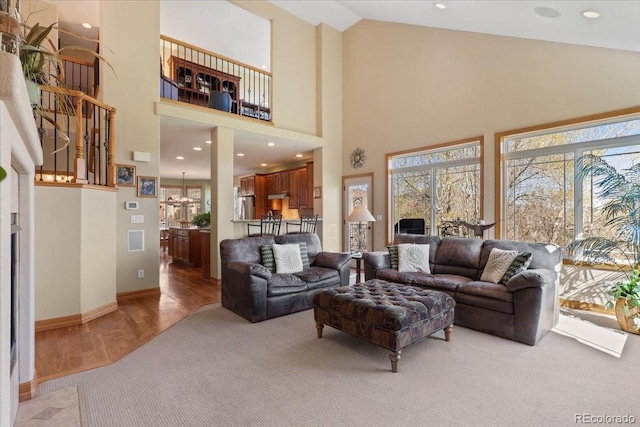 living room with light carpet, light wood finished floors, high vaulted ceiling, recessed lighting, and baseboards