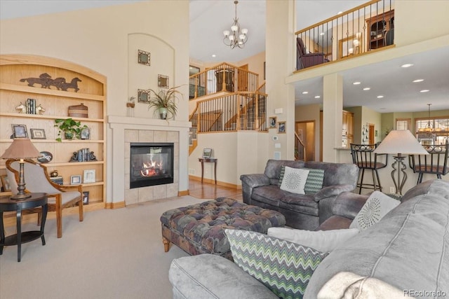 living room featuring a high ceiling, a notable chandelier, carpet floors, built in features, and stairway