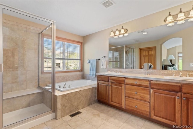 bathroom featuring tile patterned floors, a stall shower, a bath, and visible vents