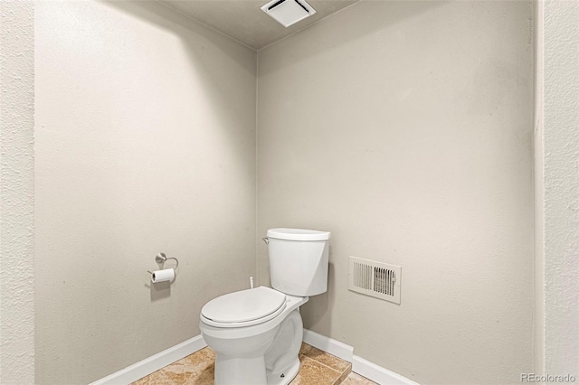 bathroom featuring toilet, tile patterned flooring, and baseboards