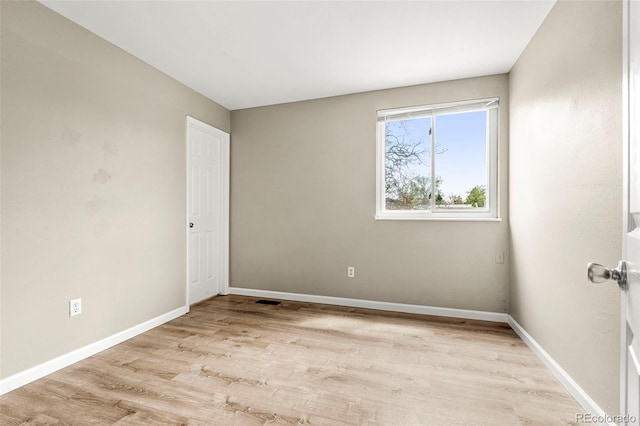 empty room with light wood-type flooring and baseboards