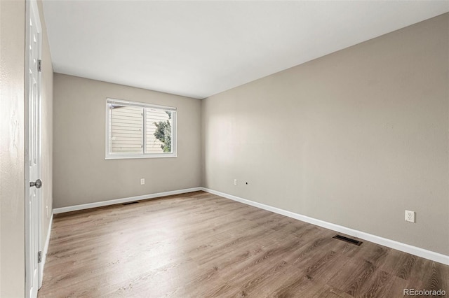 unfurnished room with wood finished floors and baseboards