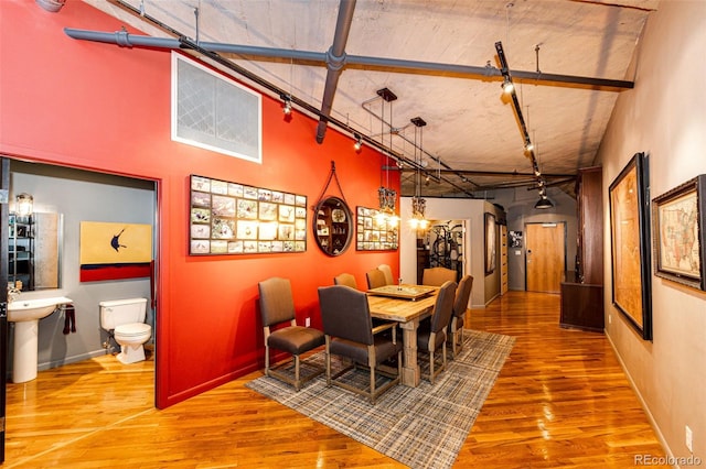 1863 Wazee St Unit 4B, Denver, CO 80202 - dining space featuring wood finished floors, rail lighting, a towering ceiling, and baseboards