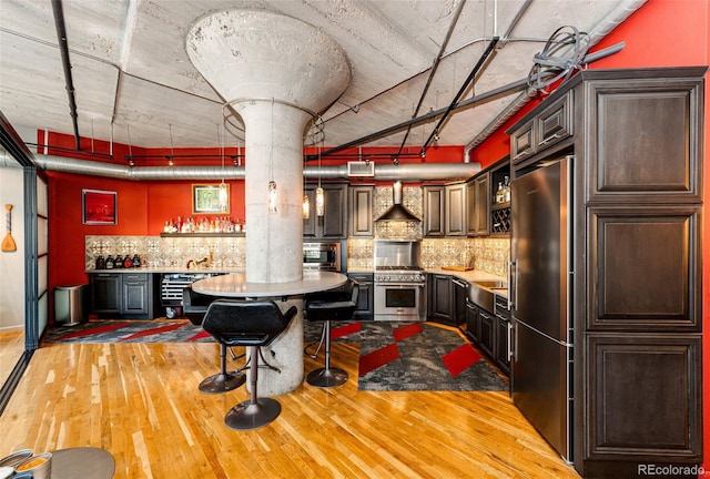 1863 Wazee St Unit 4B, Denver, CO 80202 - kitchen with premium appliances, wood finished floors, backsplash, wall chimney range hood, and butcher block counters