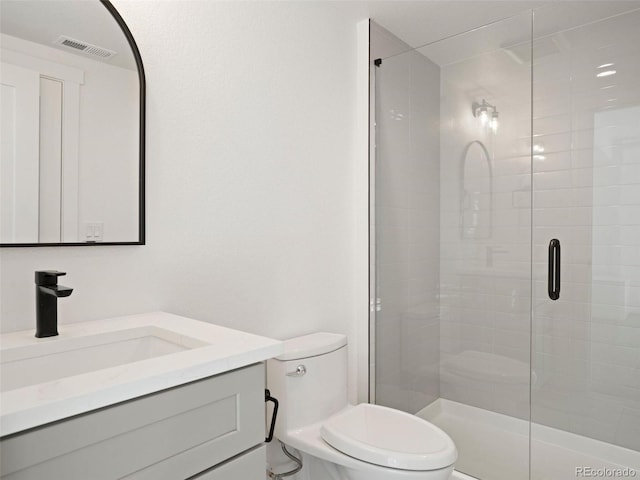 bathroom with vanity, toilet, and a shower with shower door