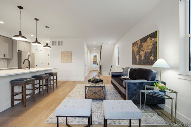 living room with sink and light wood-type flooring