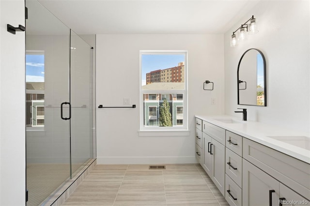 bathroom with a shower with door, tile patterned flooring, and a wealth of natural light