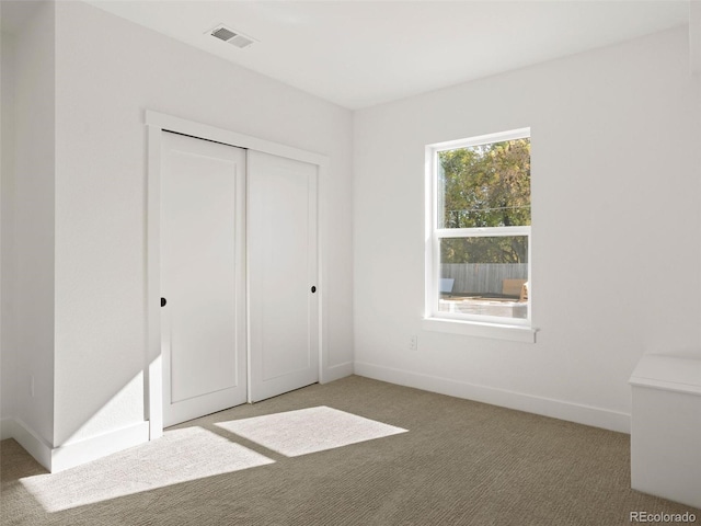 unfurnished bedroom with a closet and carpet flooring