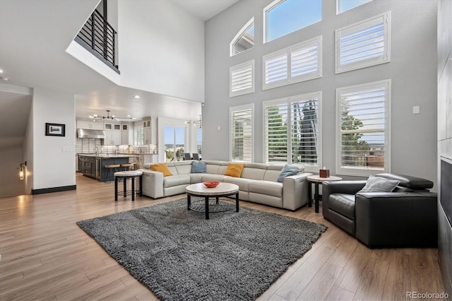 5665 Vistancia Ct, Parker, CO 80134 - living room featuring a chandelier, a high ceiling, and light wood-type flooring